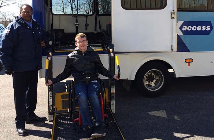 Tyler getting off the bus with his wheelchair