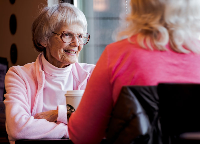 Two elders talking while having coffee in Starbucks